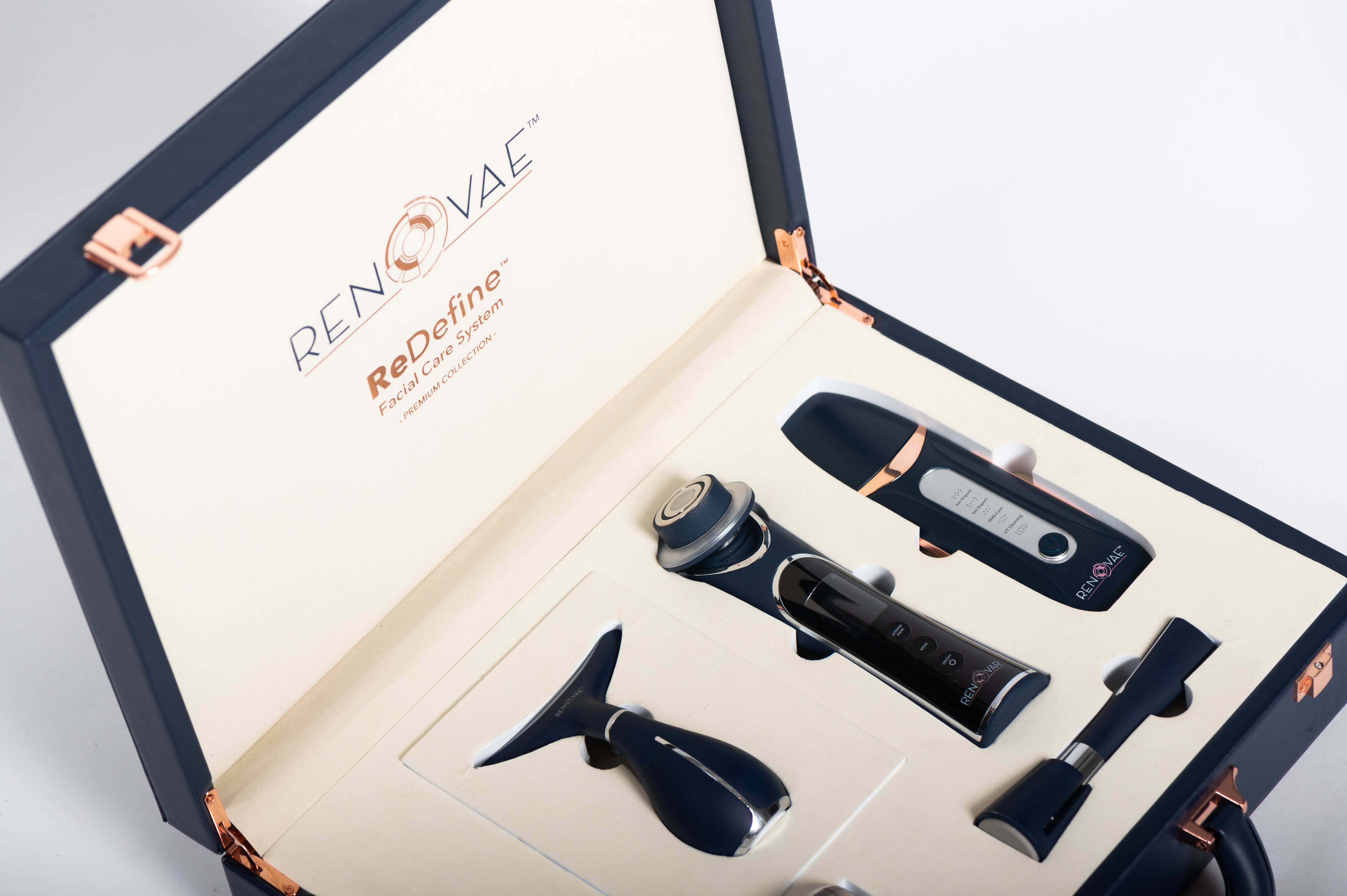 Renovae device case open, showing the navy and rose-gold in-home diagnostic devices